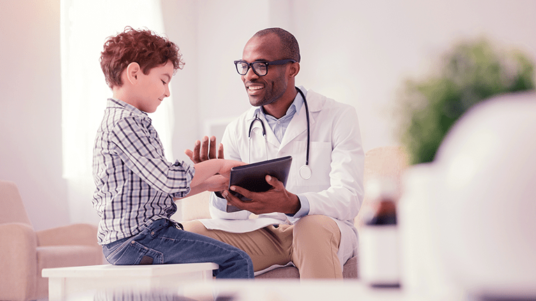 Young male Physician with patient with stethoscope in medical office.