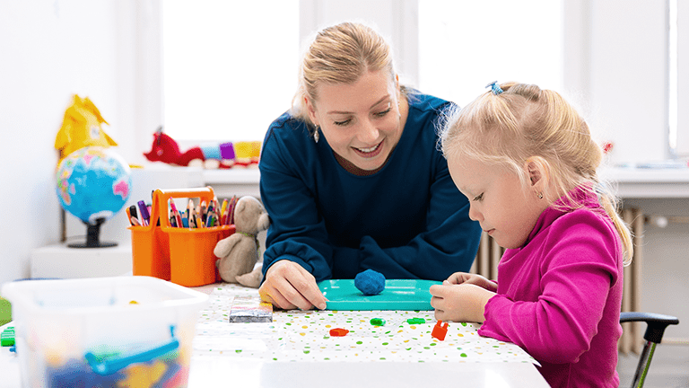 Female Occupational Therapist works with young child in a school setting.