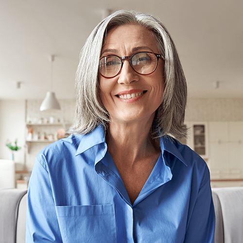 Smiling  woman looking at web camera during telehealth appointment.