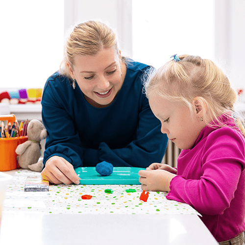 Female Occupational Therapist works with young child in a school setting.