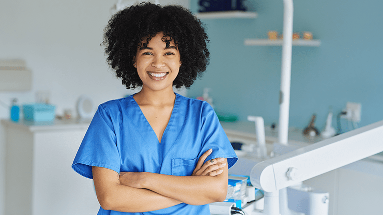 Portrait of a young woman standing in a dentist’s office.