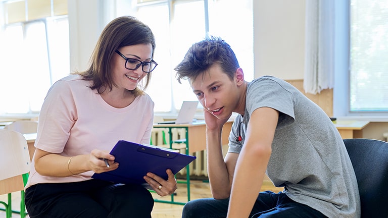 Woman school psychologist talking and helping teenage student.