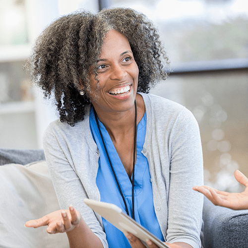 Encouraging female counselor gestures as she talks with a female client.